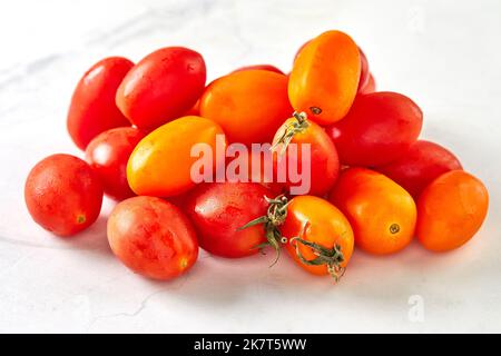 Cherry tomatoes on white marble, ready to cook and eat Stock Photo