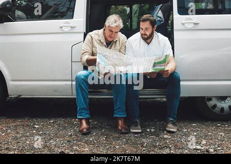 Senior man, father and son with map on travel adventure looking for destination direction in van talking and traveling together. Family, friends and Stock Photo