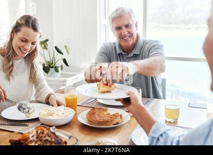 Family, food and lunch with a senior man sharing a meal with his daughter in the dining room of their home during a visit. Retirement, love and eating Stock Photo