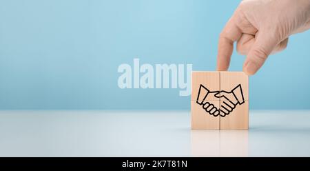 Business contract. Hand putting hand shaking which print screen on wooden cube block for business deal and agreement concept. cooperation business dea Stock Photo