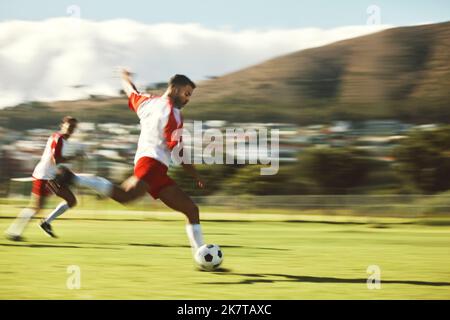 Energy, fitness and soccer training with soccer playing in power kick with ball on a soccer field for team sports game. Football, man and football Stock Photo