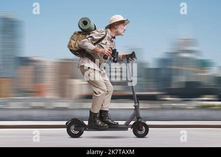 Funny senior urban explorer riding a fast electric scooter in the city street Stock Photo