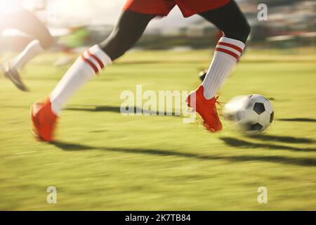 Soccer, sports and running with the shoes of a man athlete on a grass pitch or field during a game. Football, fitness and training with a male player Stock Photo