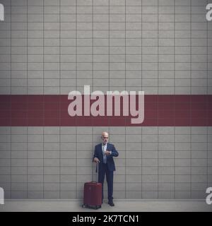 Corporate businessman waiting at the subway station, he is checking the time, travel concept Stock Photo