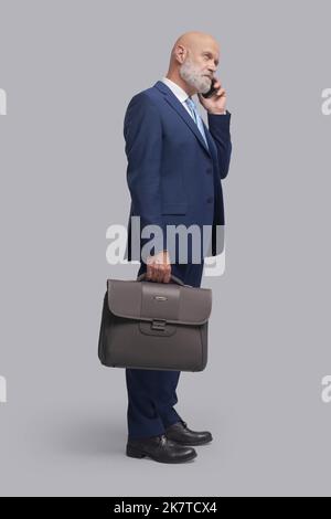 Corporate businessman having a phone call with his smartphone Stock Photo