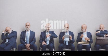 Repetition of same man waiting for a job interview, he is sitting in the waiting room and getting bored Stock Photo