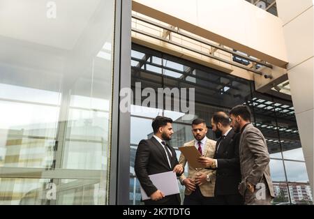 An international successful business team of male entrepreneurs in suits met to discuss development ideas. Efficient work and corporate spirit Stock Photo