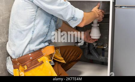 Plumber man fixing kitchen sink Stock Photo