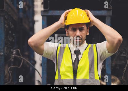 engineer worker male hand holding his head for headache shocked the problems in factory Stock Photo