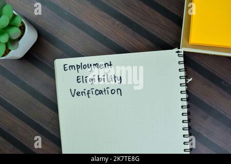 Concept of Employment Eligibility Verification write on a book isolated on Wooden Table. Stock Photo