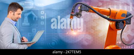 senior robotic programmer with laptop control robot welding arm for new generation industry technology banner concept Stock Photo