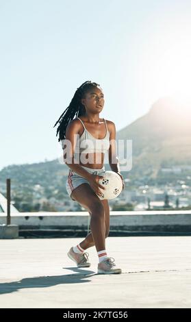 City, girl and soccer on rooftop for sports fitness training with concentration in South Africa. Exercise, football and black woman holding ball for Stock Photo