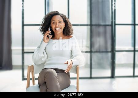 girl in the office is talking on the phone. Happy news on the phone. Stock Photo