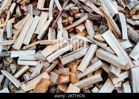Chaotically arranged in a pile of fresh chopped firewood. Preparation of firewood for the winter. Global or Europe's energy crisis concept. Logging in Stock Photo