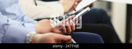 People using mobile phones on meeting, modern gadgets in work Stock Photo