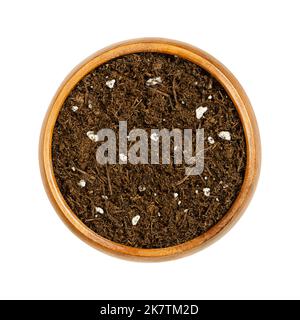 Organic potting compost, in a wooden bowl. Soft soil, growing medium and culture substrate, for sowing. Made of bog peat, humus, fibers and fertilizer. Stock Photo