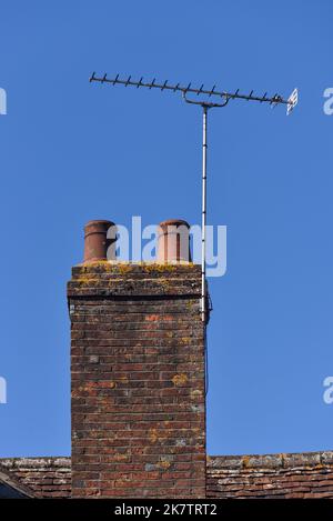 Old style brick chimney with ceramic pot on the top in a rural village in Hampshire, England. Stock Photo