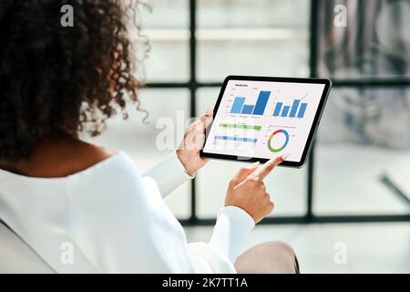 business woman analyzing a graph on the screen of a digital tablet. Stock Photo