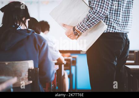 The teacher controls the exam room for students to take the exam in the classroom Stock Photo