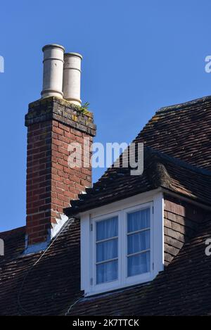 Old style brick chimney with ceramic pot on the top in a rural village in Hampshire, England. Stock Photo