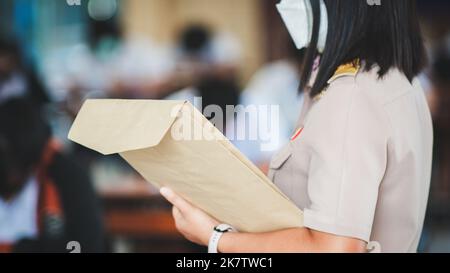 The teacher controls the exam room for students to take the exam in the classroom with wearing facemask for protection covid-19 Stock Photo