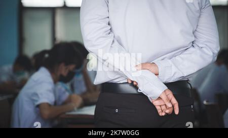 The teacher controls the exam room for students to take the exam in the classroom Stock Photo