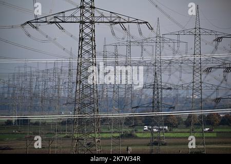 Allrath, Germany. 19th Oct, 2022. Electricity pylons stand in a field. The coal phase-out in the Rhenish coalfield in North Rhine-Westphalia is to be brought forward by eight years to 2030. In view of the current energy crisis, two lignite-fired power plants are to run longer than previously planned. Credit: Federico Gambarini/dpa/Alamy Live News Stock Photo