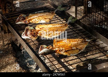 Different types of fish cooked over a fire at a food festival in Estoril, Stock Photo