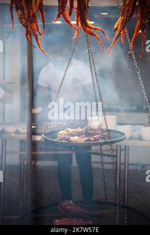 Hanging octopuses being cooked over a low heat at a food festival in Estoril, Lisbon, Portugal. Stock Photo