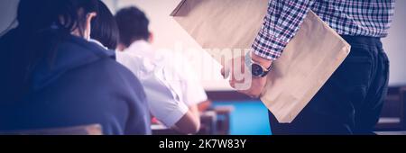 The teacher controls the exam room for students to take the exam in the classroom Stock Photo