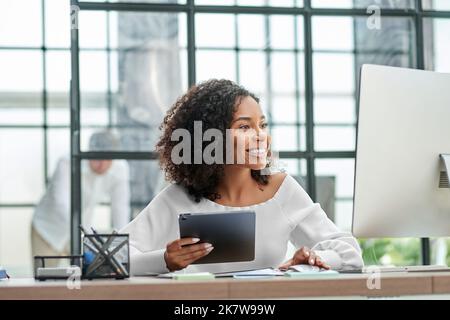successful businesswoman using a digital tablet and computer . Stock Photo