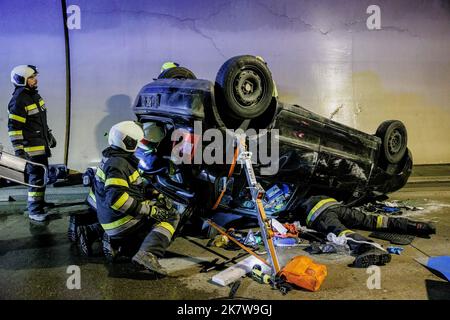An Austrian fireman tends to an accident trapped inside an overturned ...