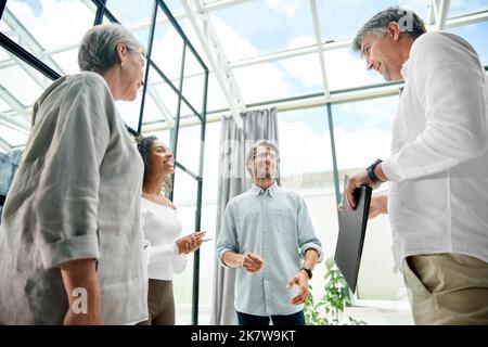 happy colleagues discussing something in the office. Stock Photo