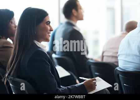 The start of tomorrow. a group of businesspeople taking notes during a meeting in an office. Stock Photo