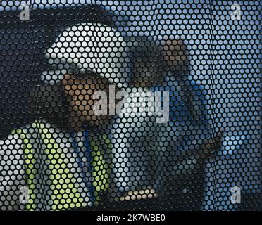 No stone left unturned. a young woman checking her notes behind a screen at work. Stock Photo