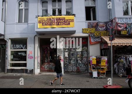 man walking by shops in front of an Apartment block with a rainbow map of the world mural in Falckensteinstraße, Kreuzberg, Berlin Stock Photo