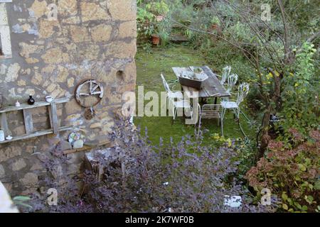Charming setting of a rustic outdoor seating area in an Italian village. Stock Photo