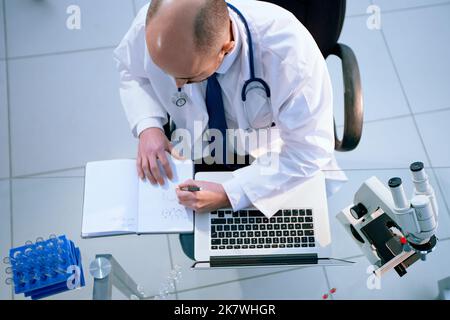 scientist taking notes during research in a medical laboratory. Stock Photo