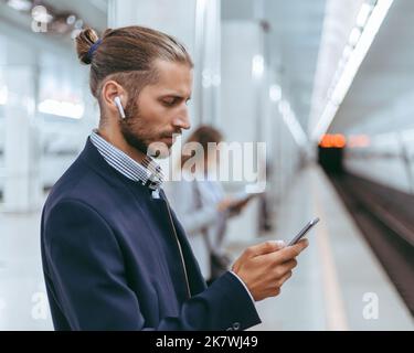 close up . business man with a smartphone while waiting for a subway train. Stock Photo