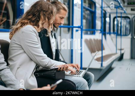 close up. young couple using laptop sitting in subway car. Stock Photo