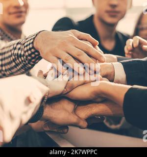 group of diverse young people joining their palms together Stock Photo