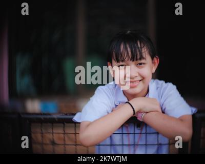 The female student smiled and laughed happily after finishing school in the evening Stock Photo