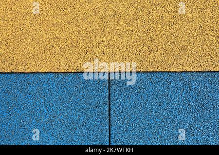 Rubber floor backdrop, texture, background. Surface in Ukrainian style. New granular rubber coating and two-colored surface. Yellow-blue carpet Stock Photo