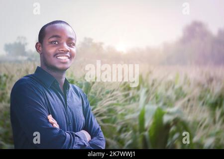 Portrait of African man farmer standing in the field on the sunset with smiling to the camera Stock Photo