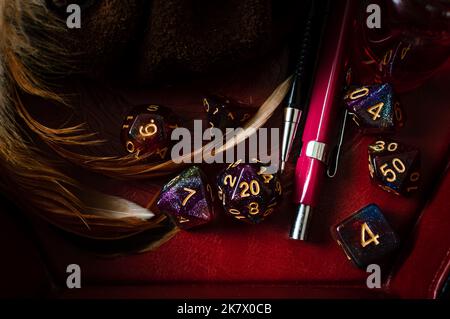 Close-up image of a set of purple glittery role-playing gaming dice and pencils in a dice tray Stock Photo