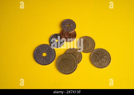 Some Danish crowns coins on a yellow surface Stock Photo