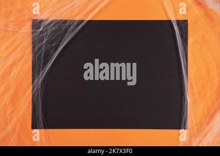 Orange and black paper background with cobwebs for Halloween Stock Photo