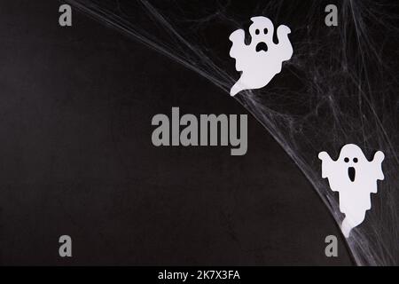 Spider web with white ghosts on black background Stock Photo