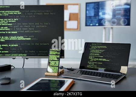Background image of computer screens with green code lines at programmers workplace Stock Photo