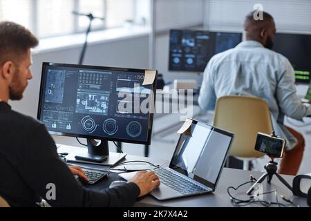 Portrait of male programmer or data specialist using computer in office with charts on screen, copy space Stock Photo